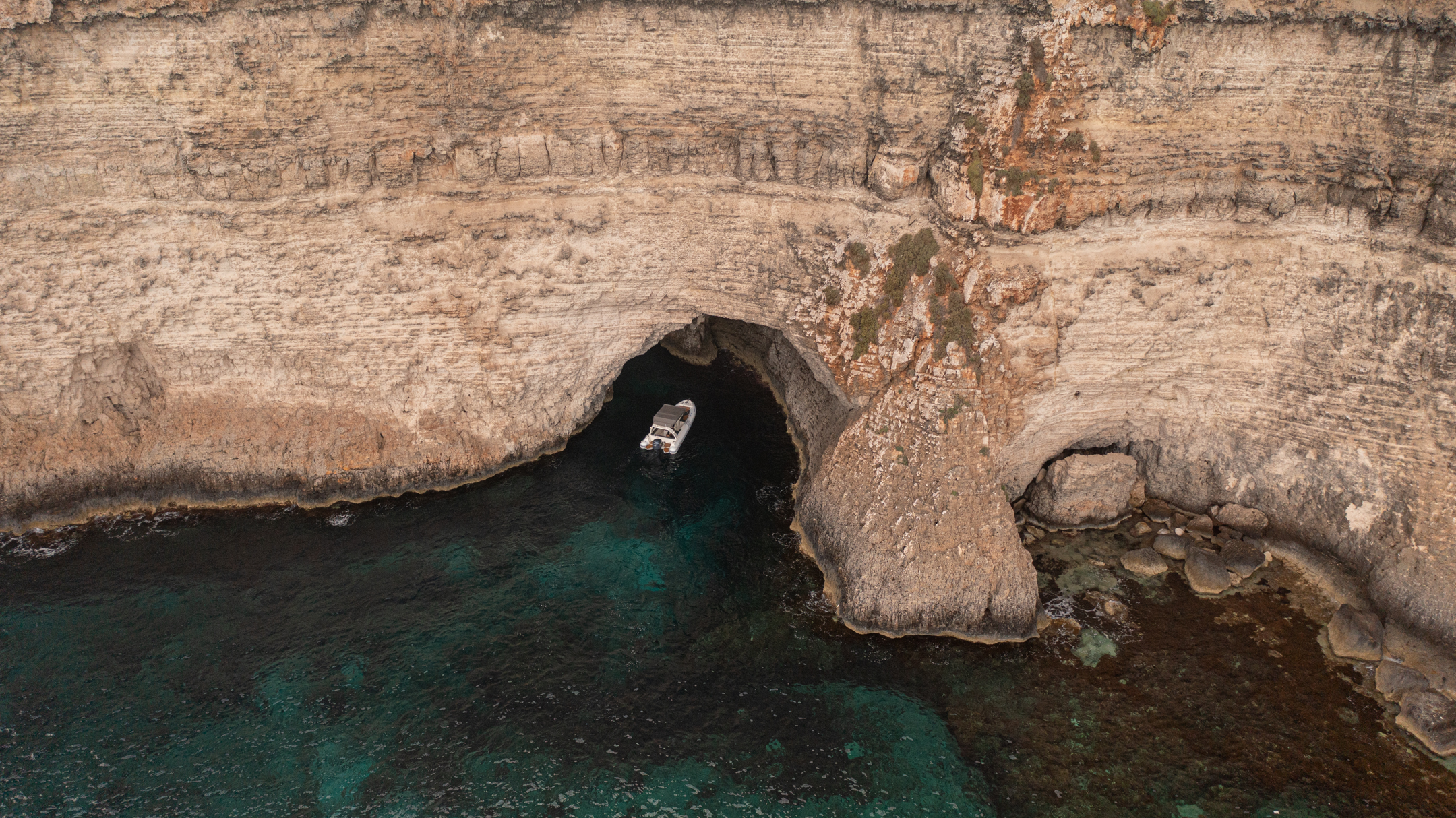 Scenic view of Lovers Cave, a hidden sea cave with turquoise waters and rugged limestone formations, offering a romantic and secluded atmosphere.