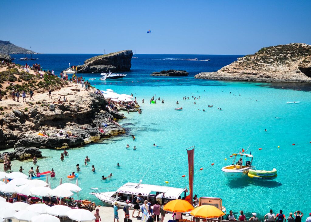 People swimming in the crystal-clear waters of the Blue Lagoon Malta