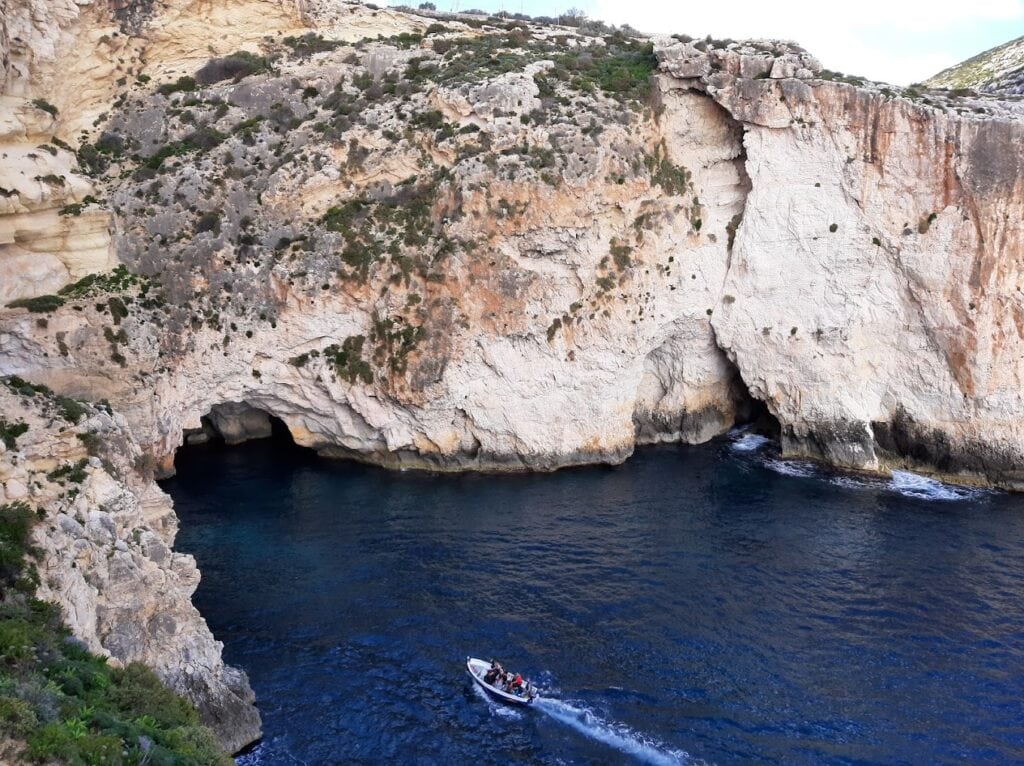 Breathtaking view of Blue Grotto Malta, showcasing majestic limestone arches and vibrant blue waters.