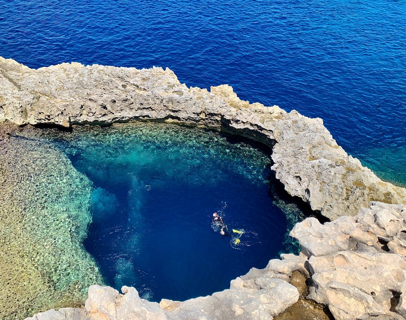 Stunning view of Dwejra Blue Hole in Gozo, one of the best places to snorkel in Malta. The crystal-clear waters and unique rock formations make it a must-visit for underwater enthusiasts. Explore this natural wonder and more with GOZOblu Private Boat Tours for an exclusive, personalised experience.