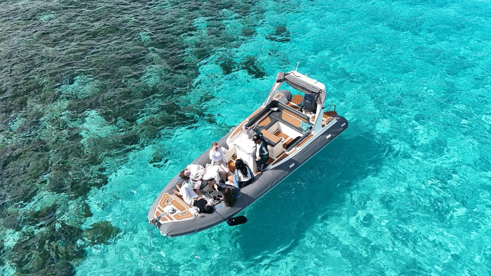 GOZOblu boat cruising through the clear blue waters on a Comino and Blue Lagoon cruise, with the scenic Maltese coastline in the background.