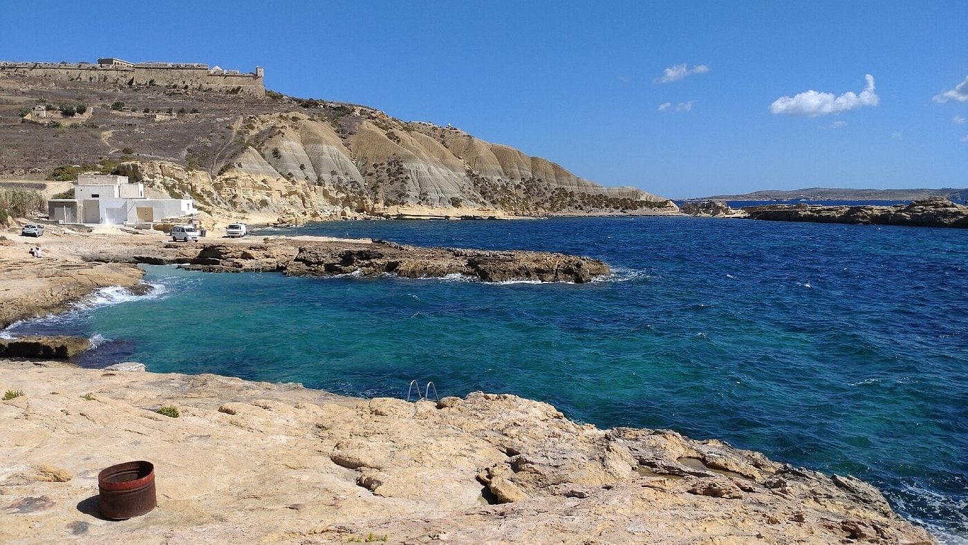 Clear turquoise waters and rocky shoreline at Xatt l-Aħmar in Gozo, one of the best places to snorkel in Malta. This peaceful coastal spot is perfect for exploring vibrant marine life and underwater landscapes, ideal for snorkelling enthusiasts seeking a hidden gem off the beaten path.
