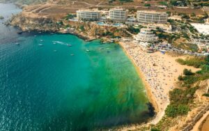Golden Bay Malta, with its golden sand beach, clear blue waters, and stunning limestone cliffs, a popular spot for swimming and sunset views.