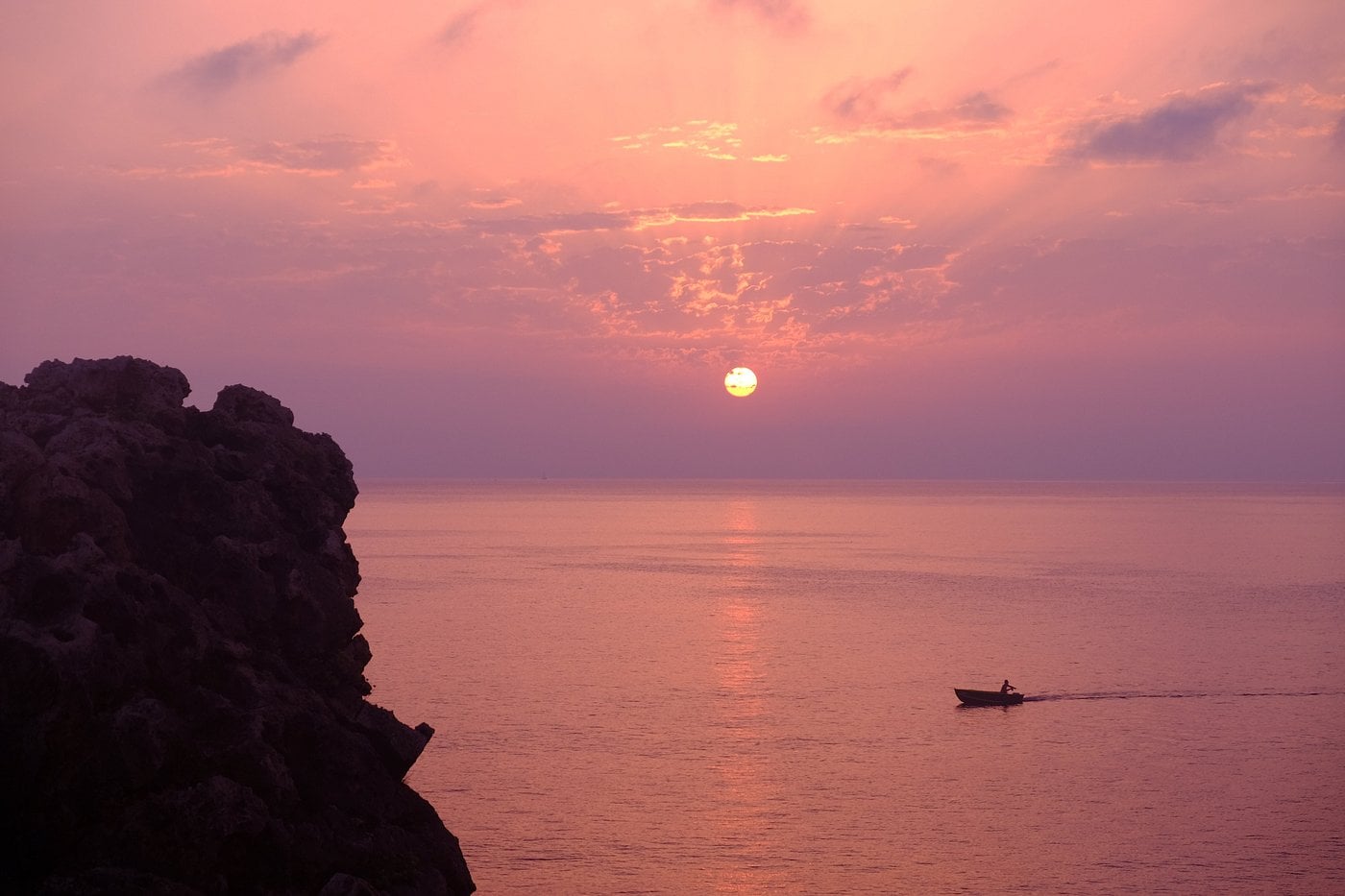 Dahlet Qorrot Beach at sunset, with golden hues reflecting on the calm sea