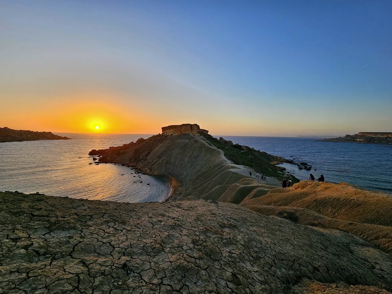 Stunning sunset over the tranquil waters of Ġħajn Tuffieħa Bay, Malta, with golden skies and peaceful waves