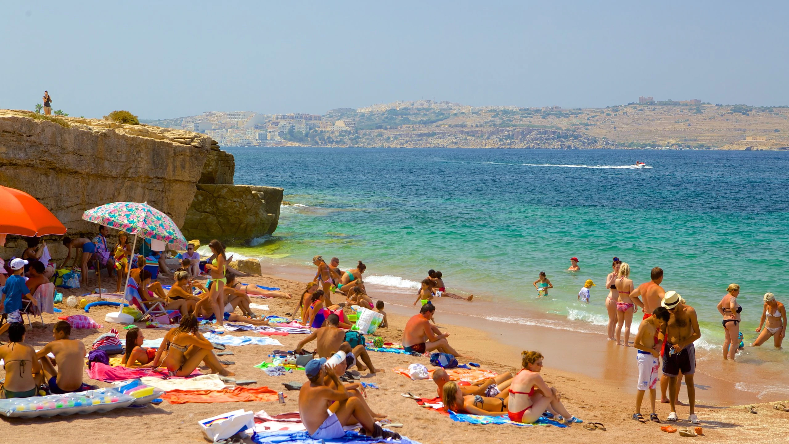 Tourist sunbathing and swimming in bugibba beach