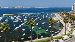 Beautiful coastal view of St. Paul’s Bay, Malta, with crystal-clear waters and picturesque boats. Explore the top things to do in st paul's bay from swimming and snorkelling to discovering nearby islands on a private boat tour.