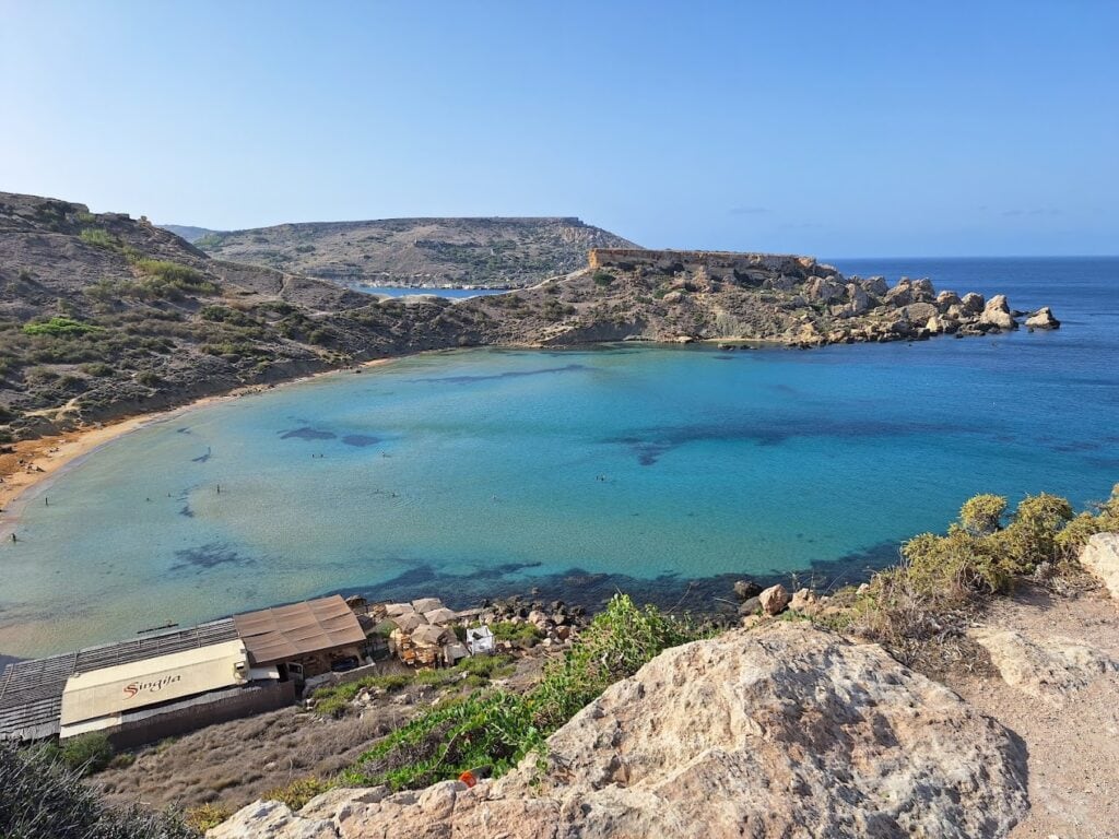 Secluded southern shore of Ġħajn Tuffieħa Bay in Malta featuring golden sands, clear waters, and peaceful natural scenery