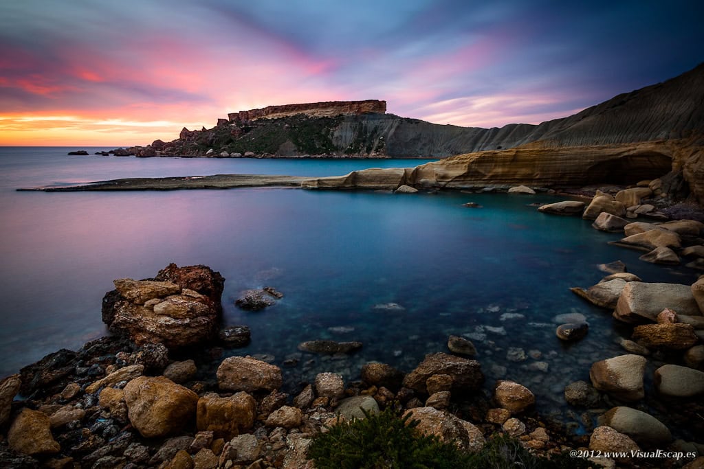 Scenic view of Ġnejna Bay in Malta with golden sands, clear turquoise waters, and surrounding limestone cliffs—perfect for swimming, sunbathing, and cliffside hikes.
