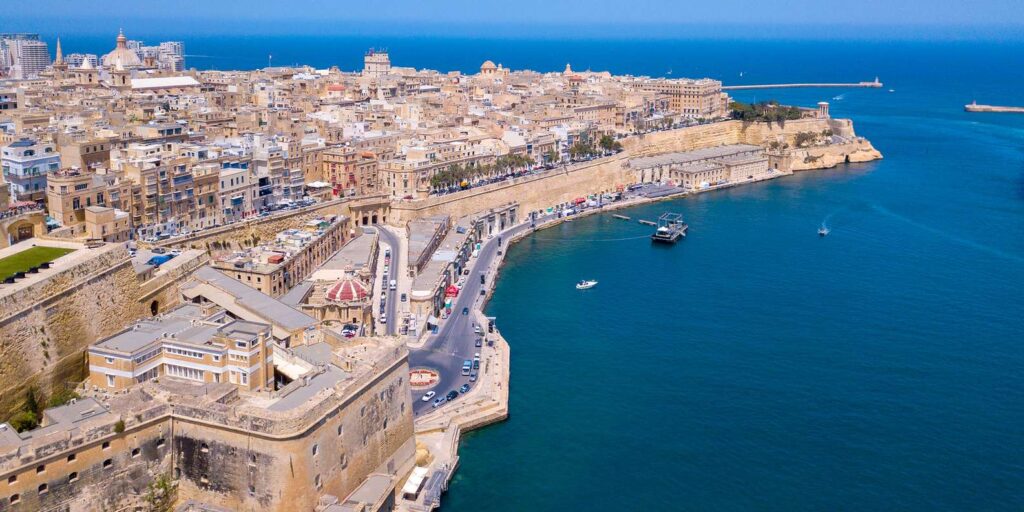 Scenic coastal view of Malta with crystal-clear waters and rugged cliffs, a popular destination for cruise ship excursions exploring the island’s natural beauty and historic sites.