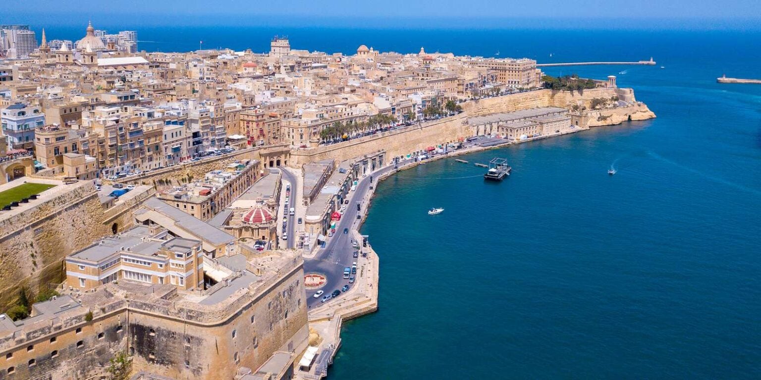 Scenic coastal view of Malta with crystal-clear waters and rugged cliffs, a popular destination for cruise ship excursions exploring the island’s natural beauty and historic sites.