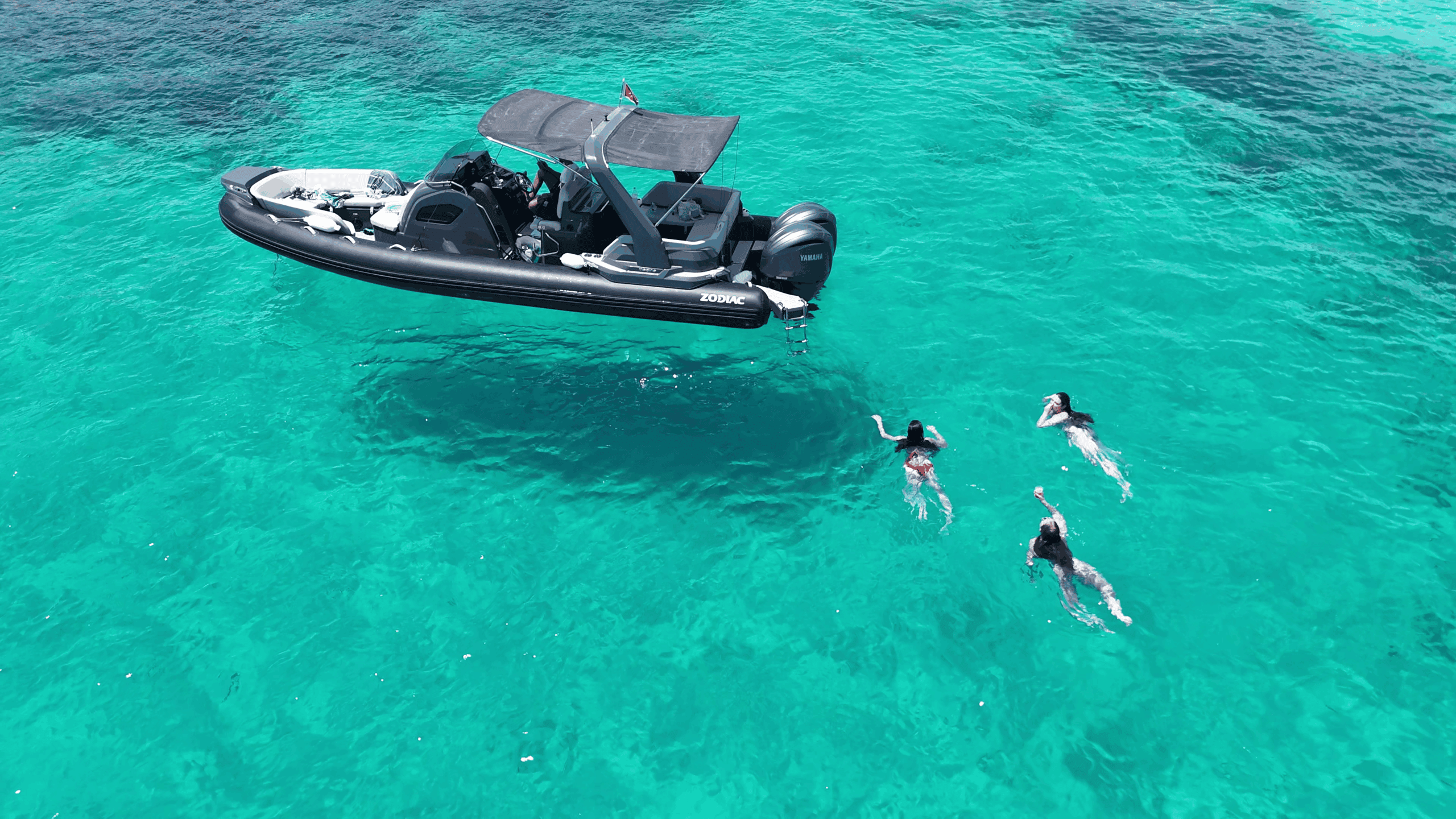Three guests swimming during a Gozo Comino & Blue Lagoon Cruise with GOZOblu Private Boat Tours, enjoying clear turquoise waters between Gozo and Comino.