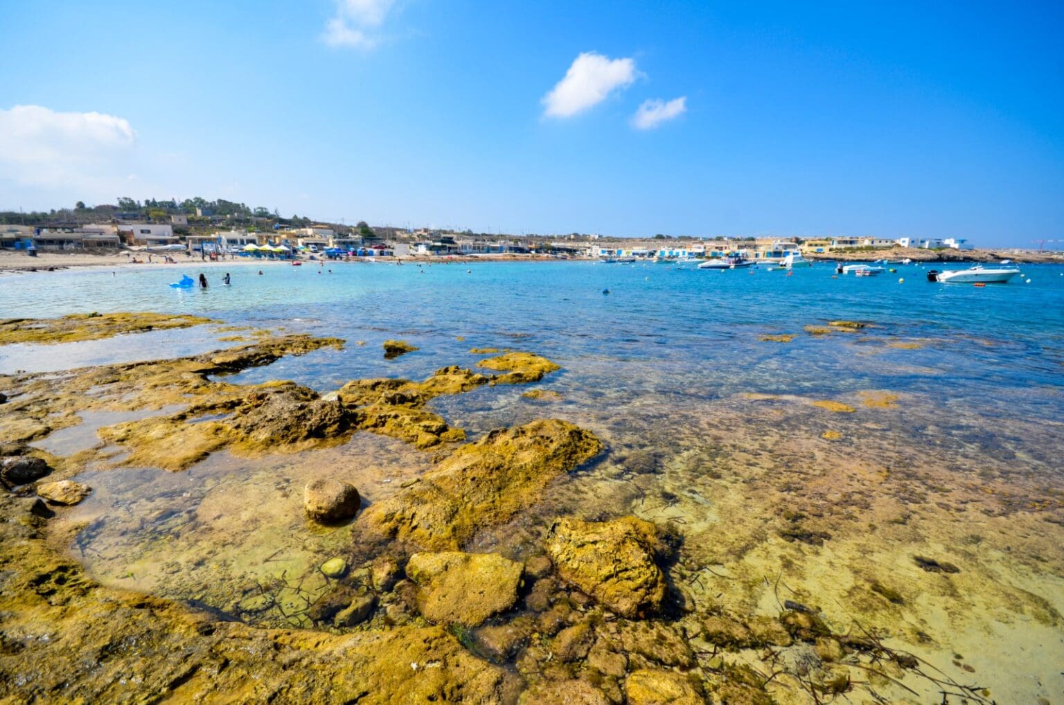 Scenic view of Armier Bay Malta with crystal-clear turquoise waters and rocky coastline