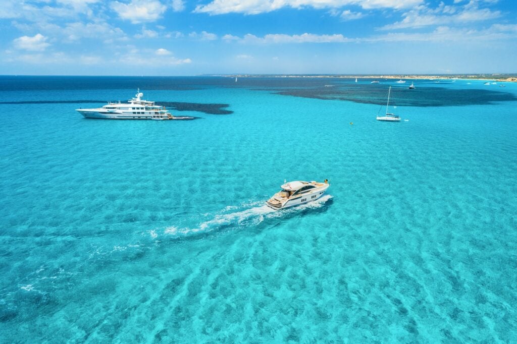 Boat sailing in the clear blue sea on a scenic trip from Valletta to Blue Lagoon, showcasing Malta’s stunning coastal views.