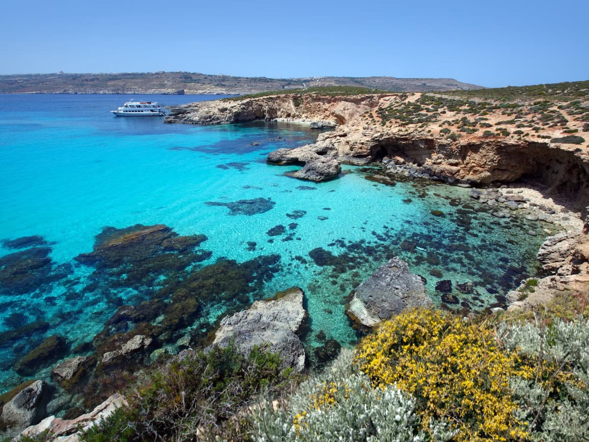 Rocky coastline with crystal-clear turquoise water, one of the best places to swim in Malta, ideal for snorkelling and sunbathing.