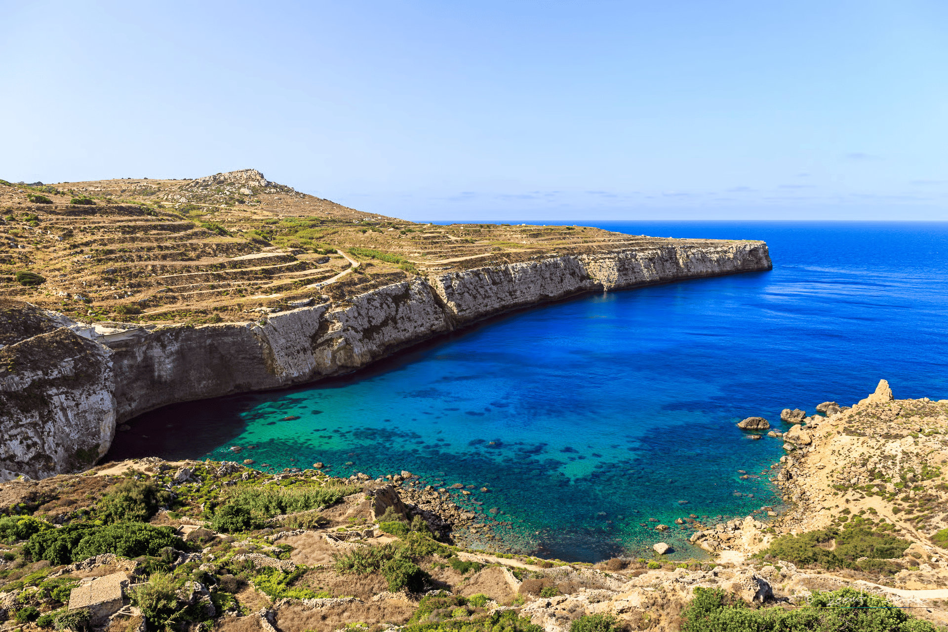 Scenic coastal view of Fomm ir-Rih Bay Malta with turquoise waters, rugged cliffs, and untouched natural landscape.