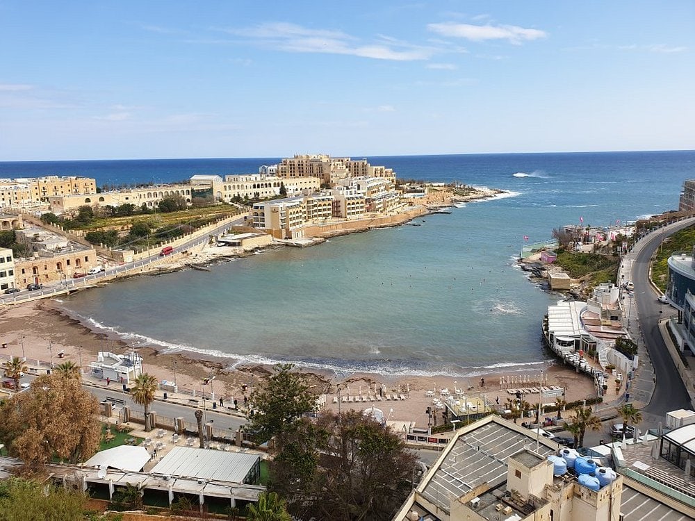 Scenic view of St. George's Bay, one of the popular sandy beaches near Valletta with clear blue waters and a relaxing atmosphere.
