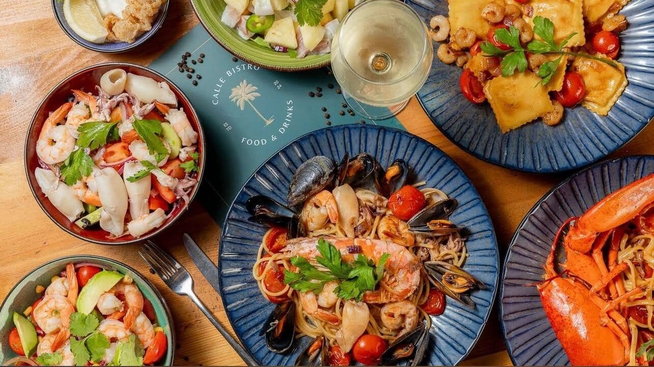 Assorted Mediterranean seafood dishes including prawns, mussels, lobster, and pasta served on a table, showcasing fresh coastal cuisine from the best restaurants in Marsaxlokk.