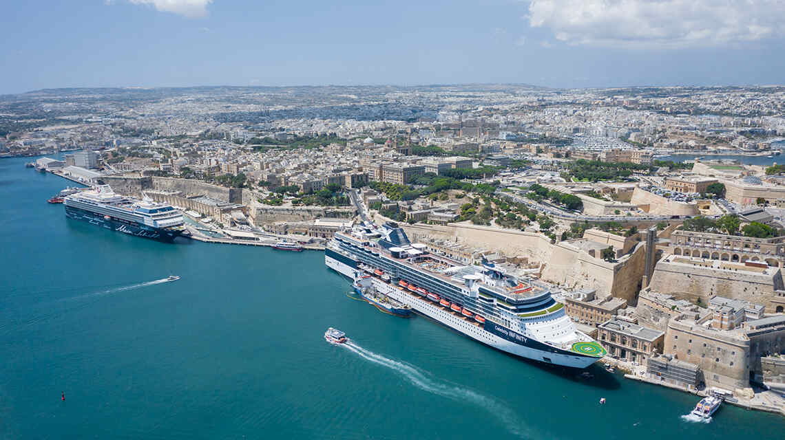 A panoramic view of Valletta’s historic waterfront at the Malta cruise ship port, with cruise liners docked beside the city’s sandstone buildings and fortifications.
