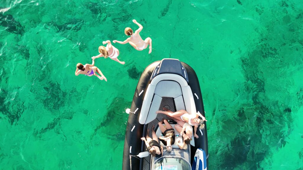 Friends enjoying a private boat trip in Malta, cruising across crystal-clear waters and taking in the beautiful Mediterranean coastline.