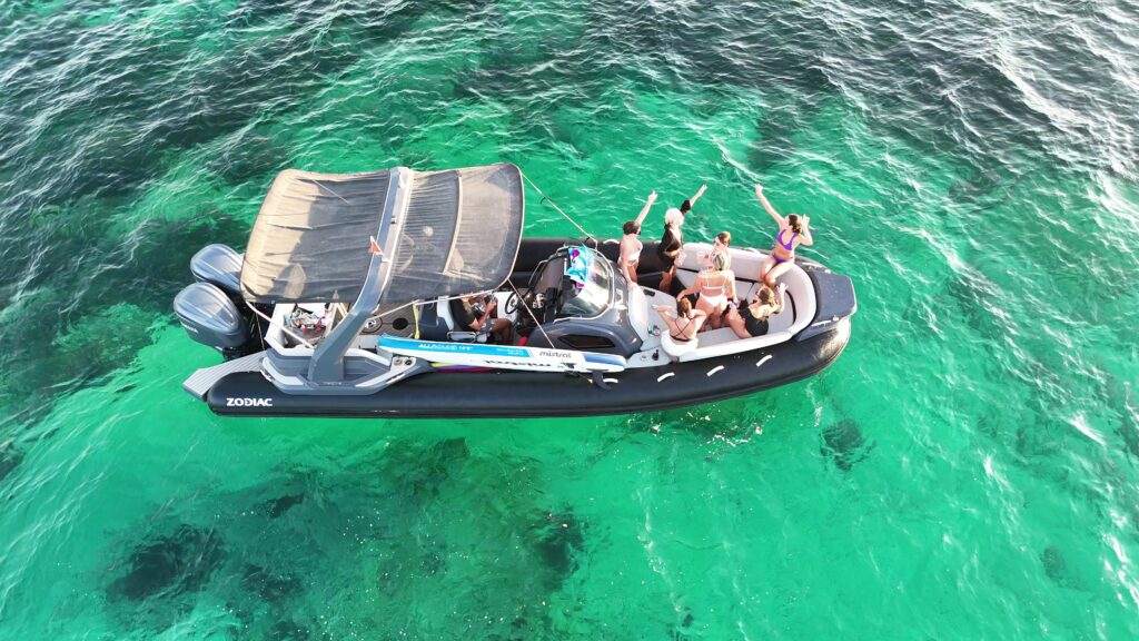 Friends enjoying a private boat tour in Malta, cruising across crystal-clear waters and taking in the beautiful Mediterranean coastline.
