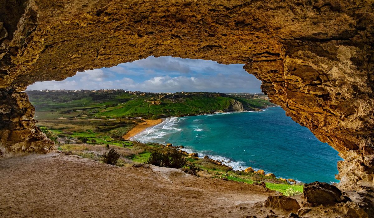 Calypso Cave Scenic view from Calypso Cave overlooking Ramla Bay, showcasing golden sands, turquoise waters, and lush green hills in Gozo, Malta.