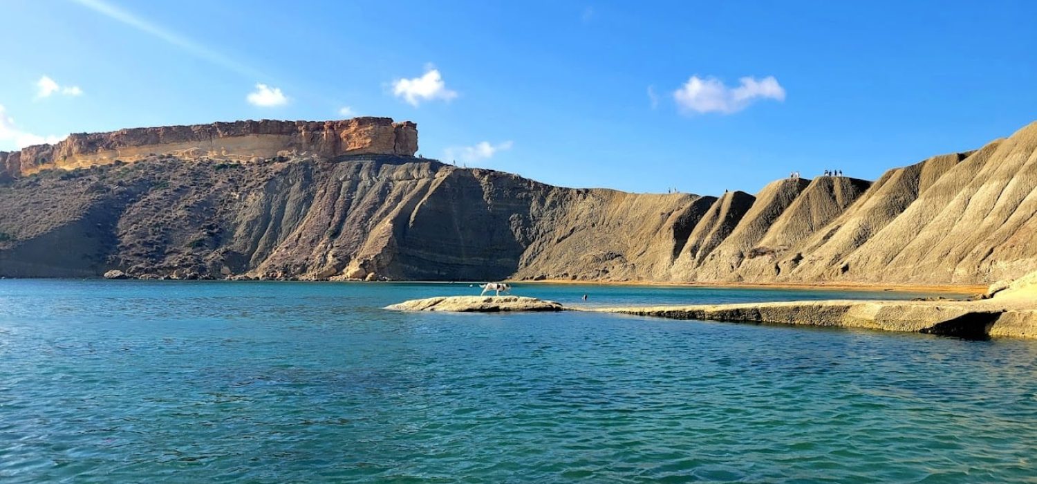 Local cliff jumping spot at Għajn Tuffieħa Bay in Malta, featuring clear blue waters and scenic limestone cliffs.