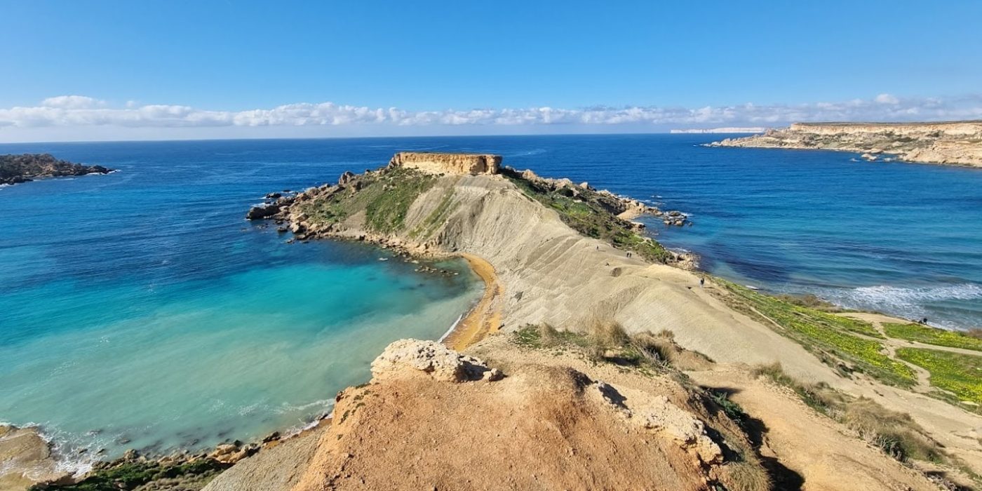 Scenic view from Il-Qarraba Viewpoint overlooking Ġħajn Tuffieħa Bay, Malta, with cliffs, turquoise waters, and untouched natural landscapes.