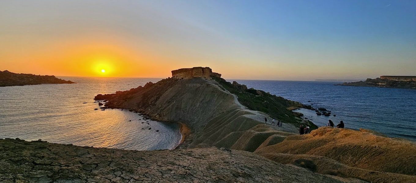 Ġħajn Tuffieħa Bay Stunning sunset over the tranquil waters of Ġħajn Tuffieħa Bay, Malta, with golden skies and peaceful waves