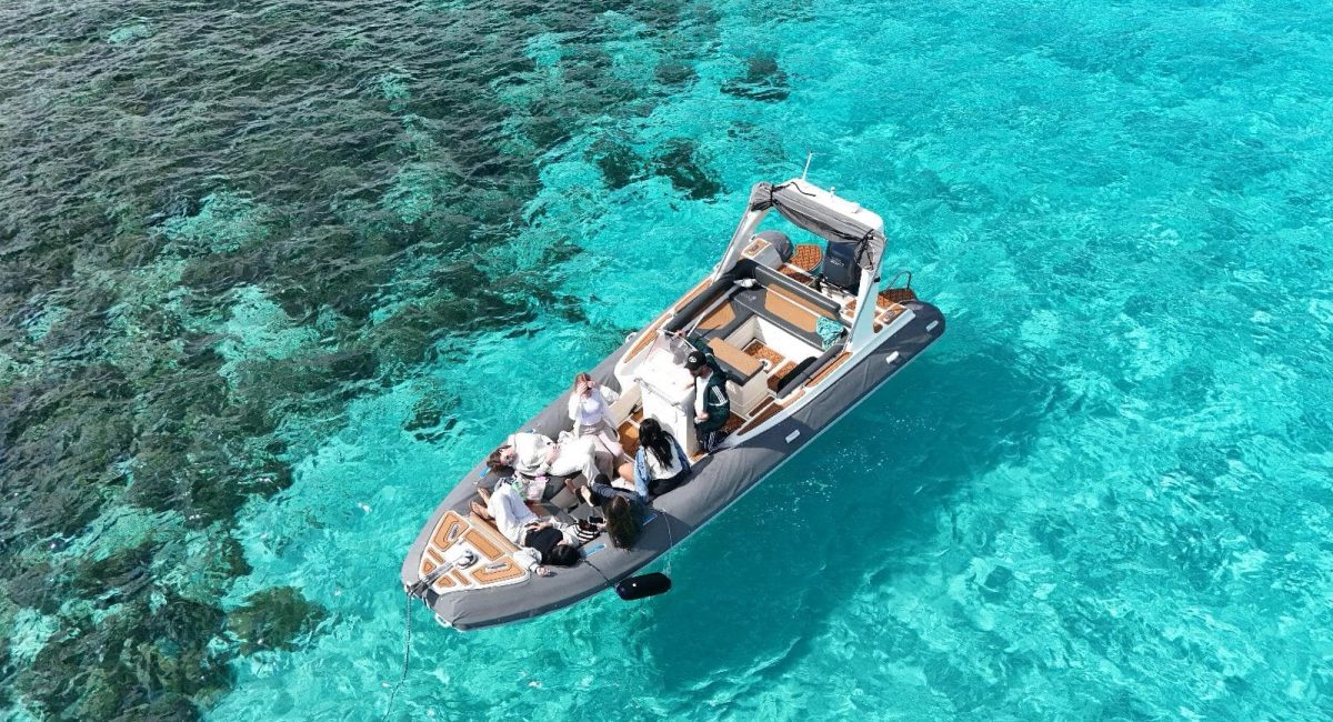 GOZOblu boat cruising through the clear blue waters on a Comino and Blue Lagoon cruise, with the scenic Maltese coastline in the background.