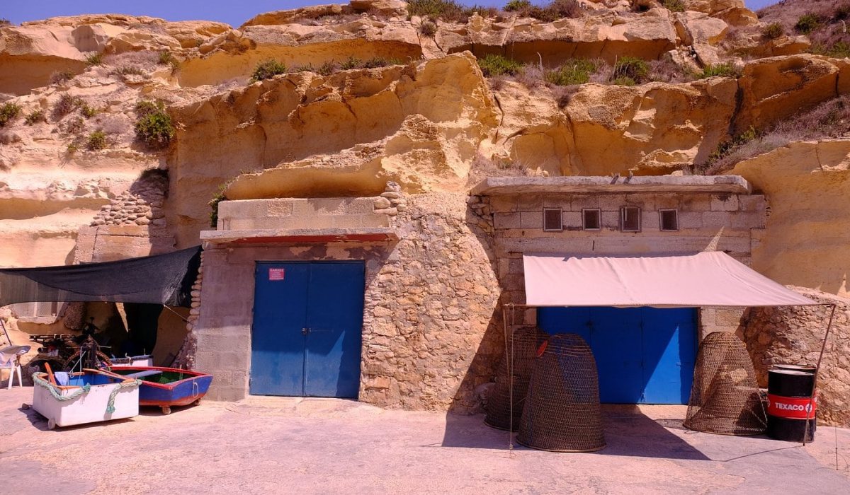 Dahlet Qorrot boathouses in Gozo, Malta, with colourful doors carved into the rocky shoreline
