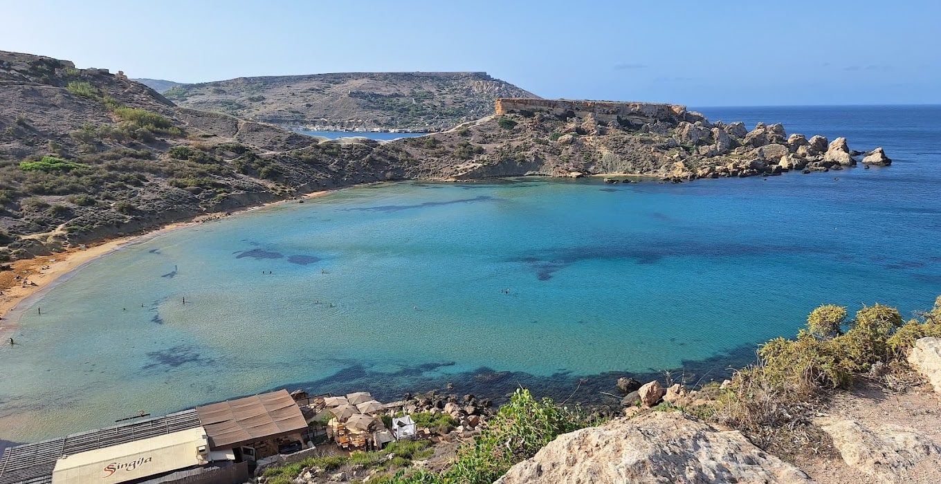 Ġħajn Tuffieħa Bay Secluded southern shore of Ġħajn Tuffieħa Bay in Malta featuring golden sands, clear waters, and peaceful natural scenery